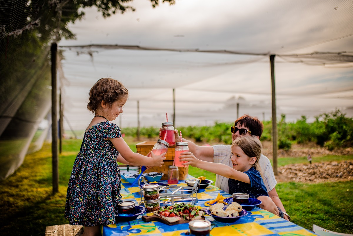 grandma and two grand children having a picnic in the patch