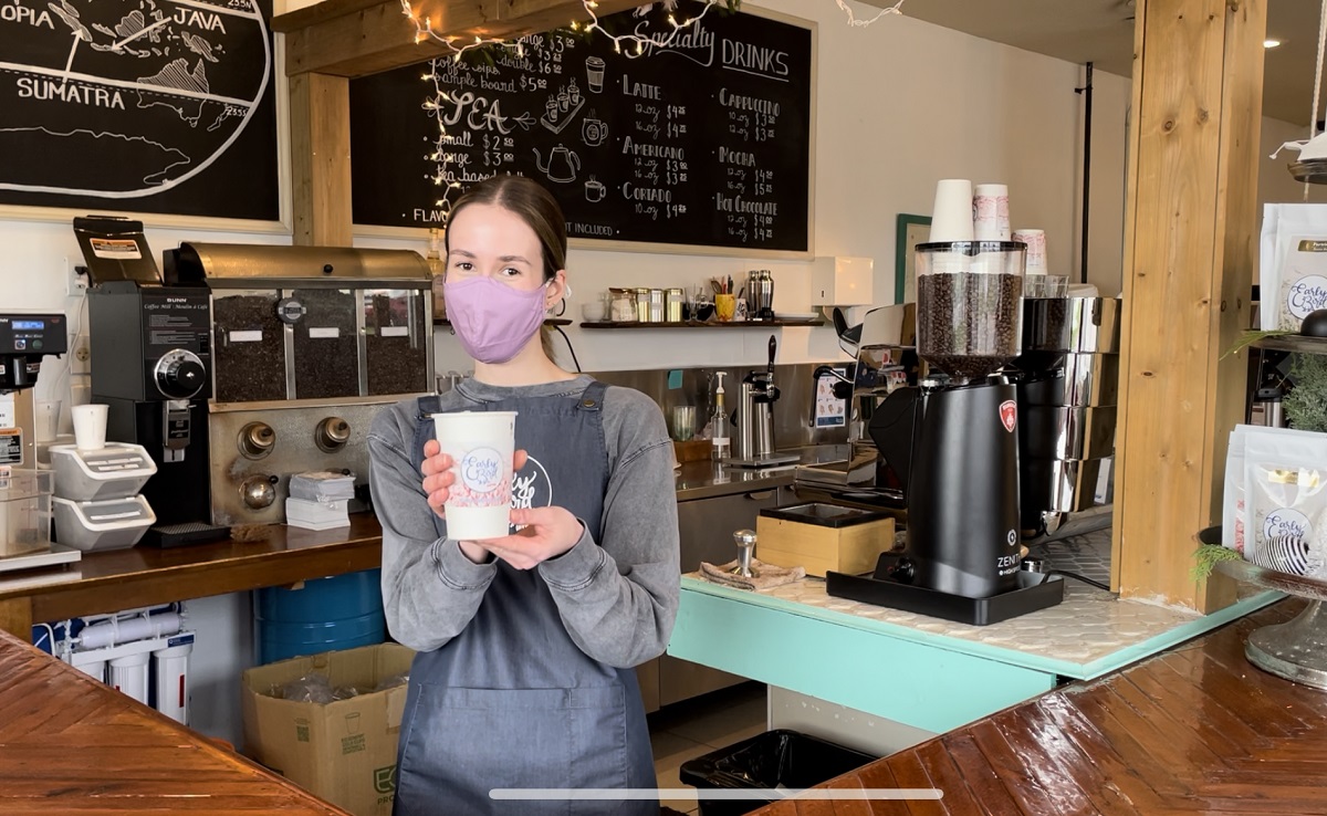 Staff holding eggnog latte at Early Bird Coffee