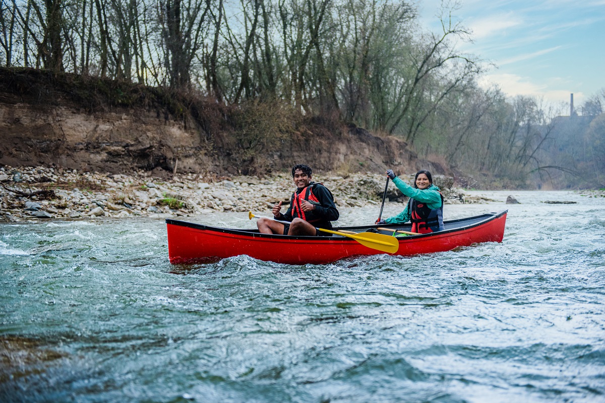 couple paddling rapids in a canoe