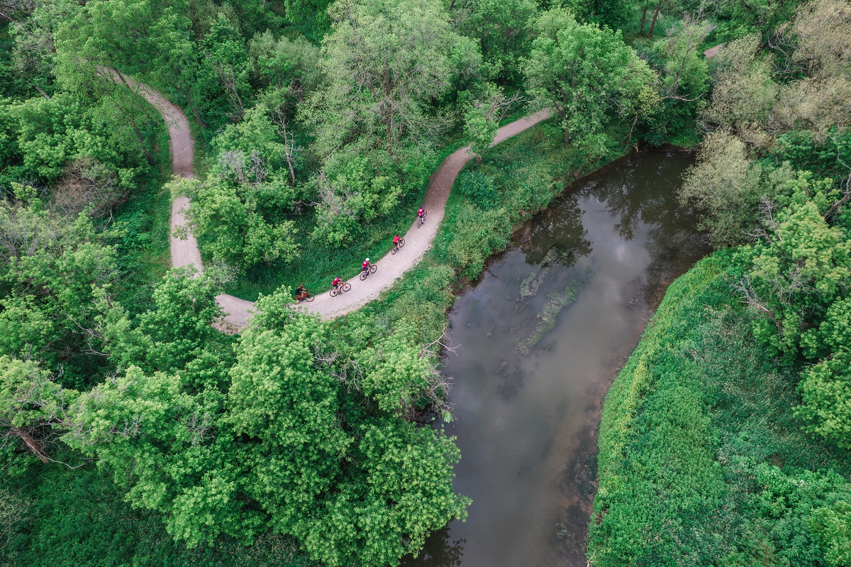 aerial shot of gravelocity cyclists above river