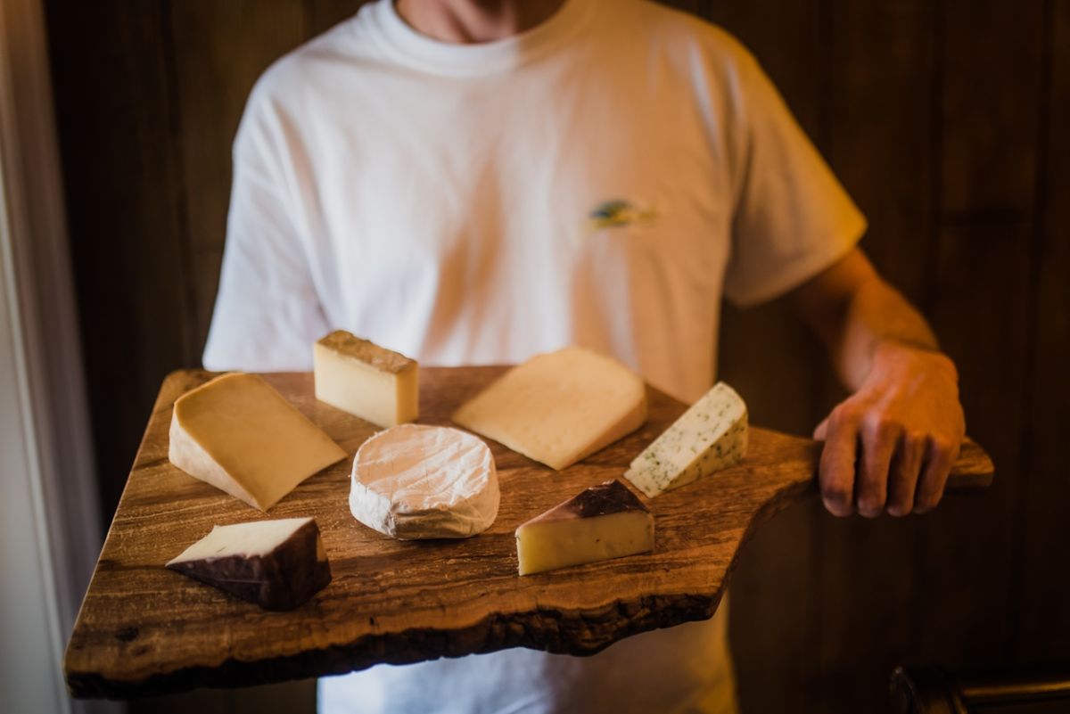 shep holding a board full of cheese