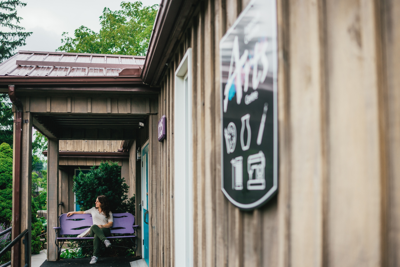 visitor sits on bench outside Ingersoll Creative Arts Centre