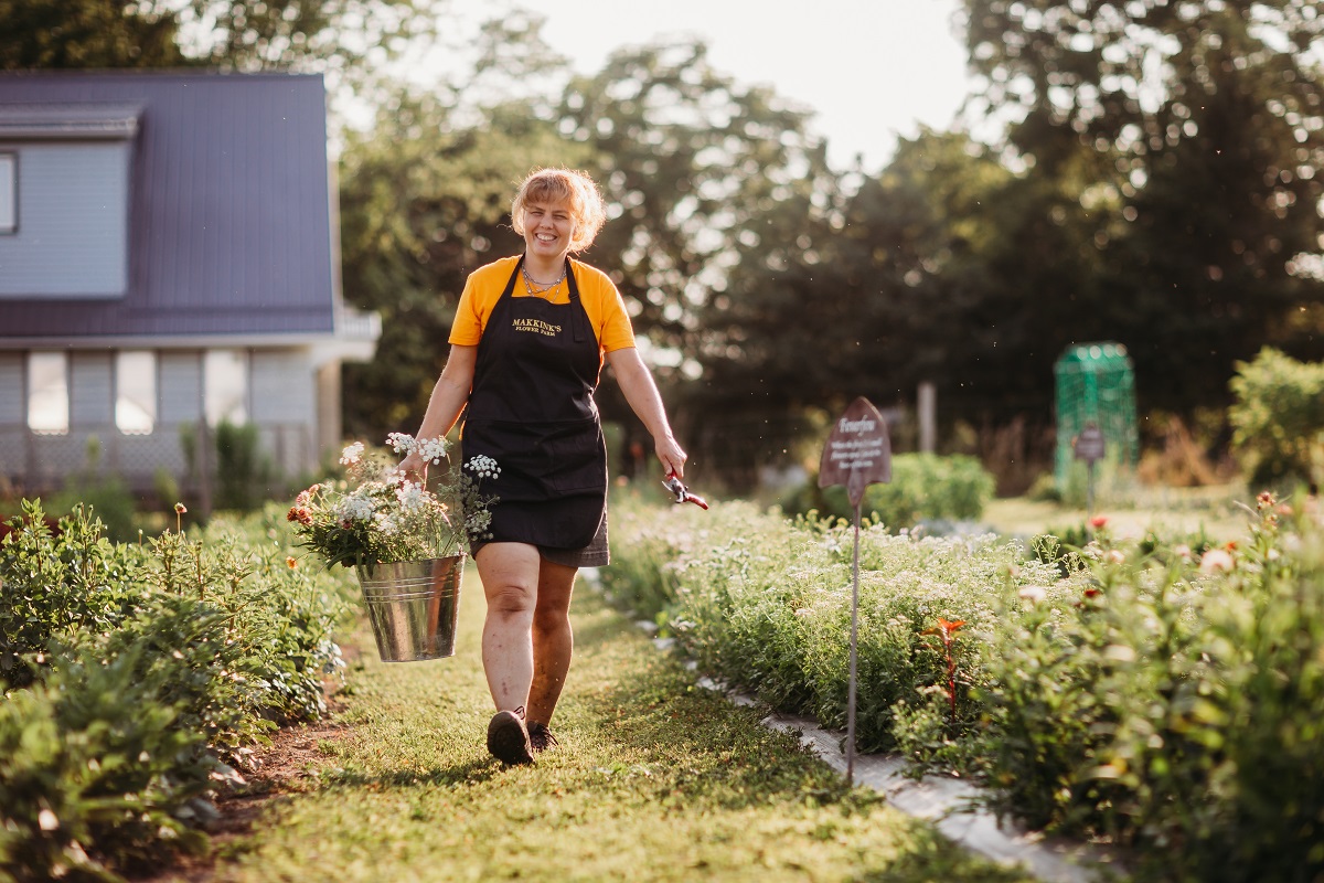 Smiling woman with freshly picked flower bouquet at makkink