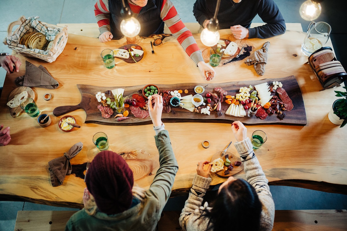 people sitting around a charcuterie feast at Ottercreek Woodworks