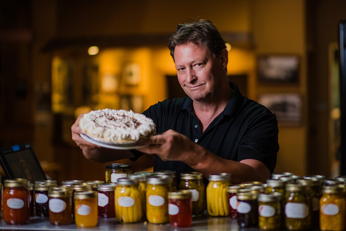 brian in front of preserves holding a pie at quehls
