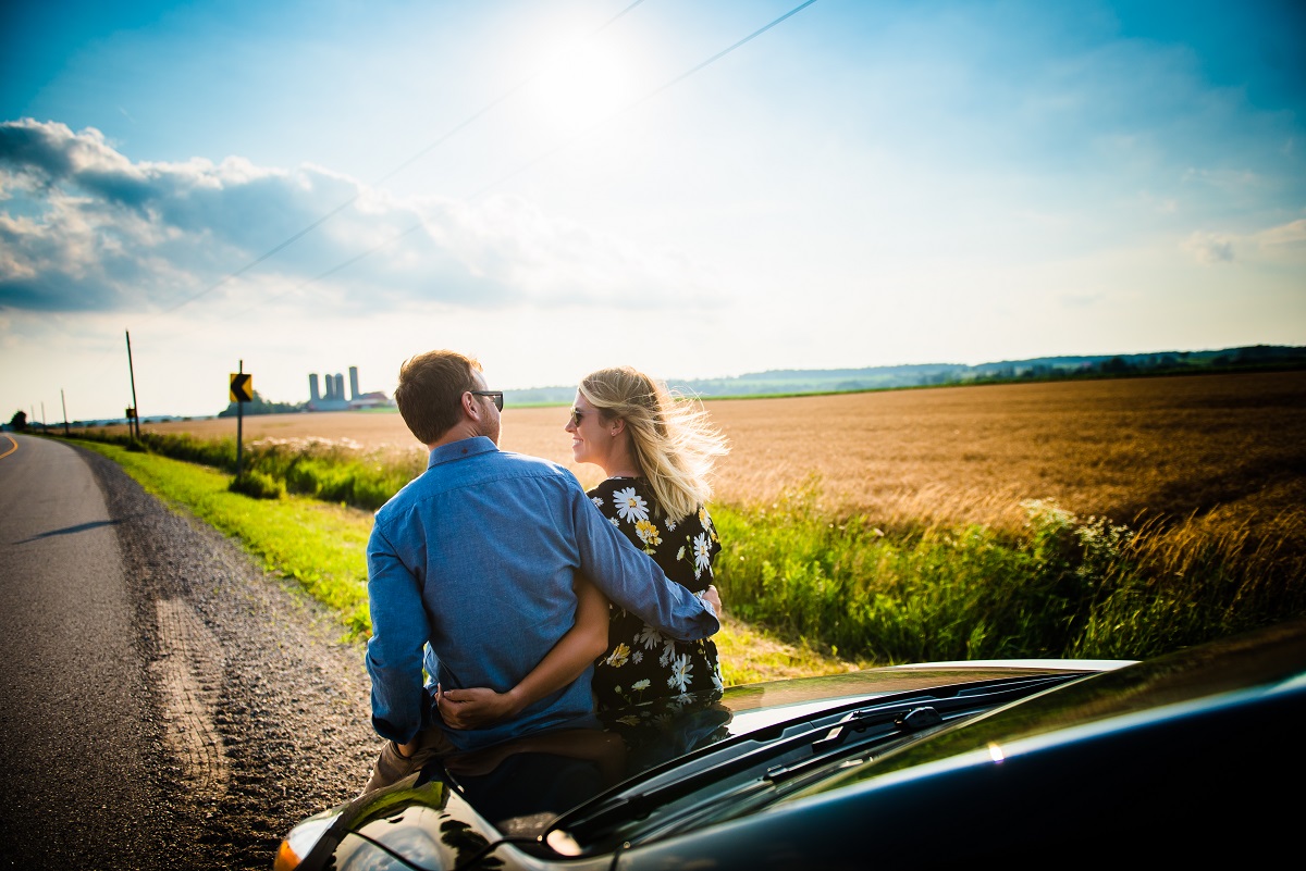 Couple leaned against their car on the Cheese Trail