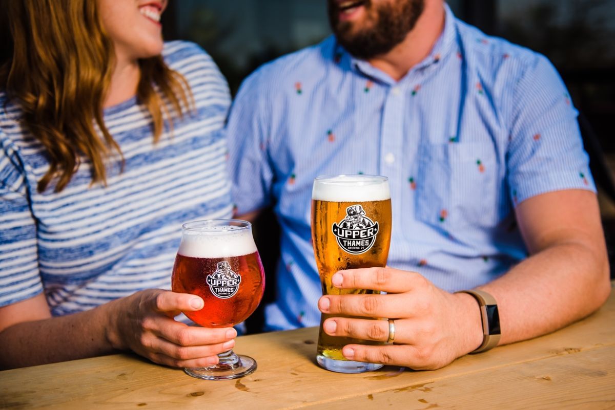 couple holding beers on the patio